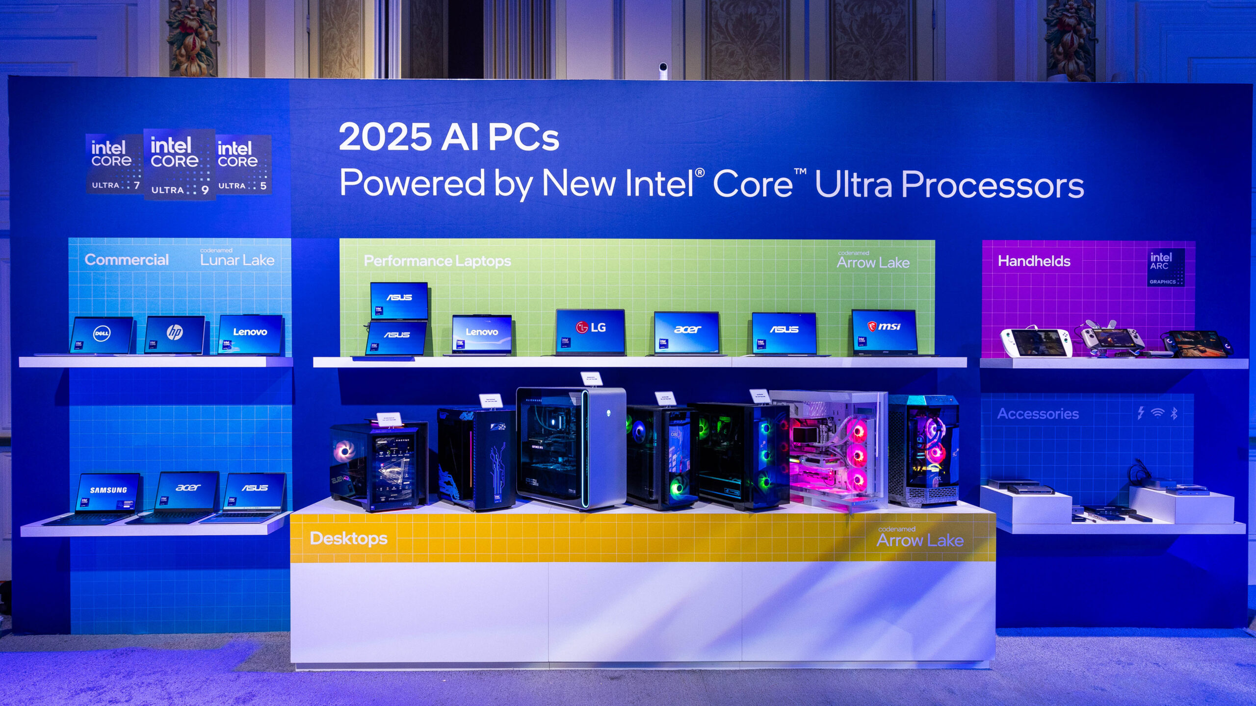 A display showcasing 2025 AI PCs powered by Intel Core Ultra processors. The exhibit includes a variety of laptops and desktops from brands like Asus, Lenovo, and LG, organized into categories like Commercial, Performance Laptops, and Desktops.